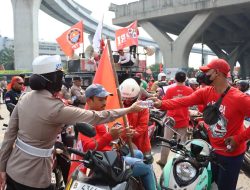 *Aksi Humanis Polres Pelabuhan Tanjung Priok Bagikan Minum dan Roti Saat Buruh Rayakan May Day*
